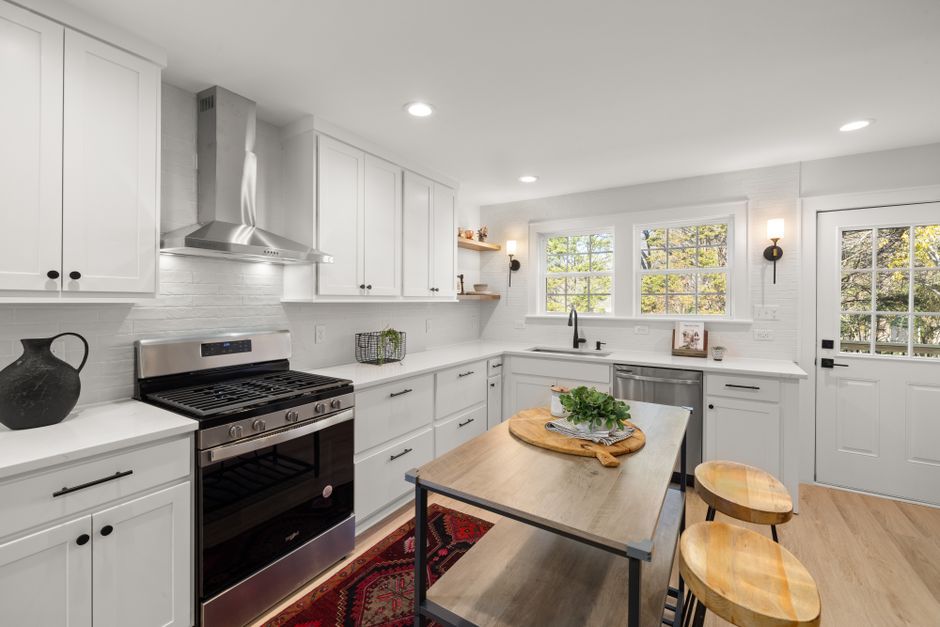 Sleek contemporary kitchen design featuring white cabinetry and stainless steel appliances.